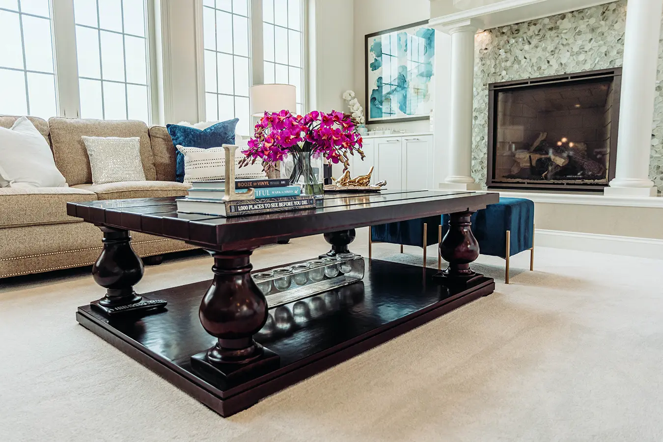 dark coffee table with books and pink flowers